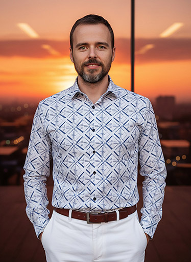 Muž ve vzorované košili s výhledem na západ slunce